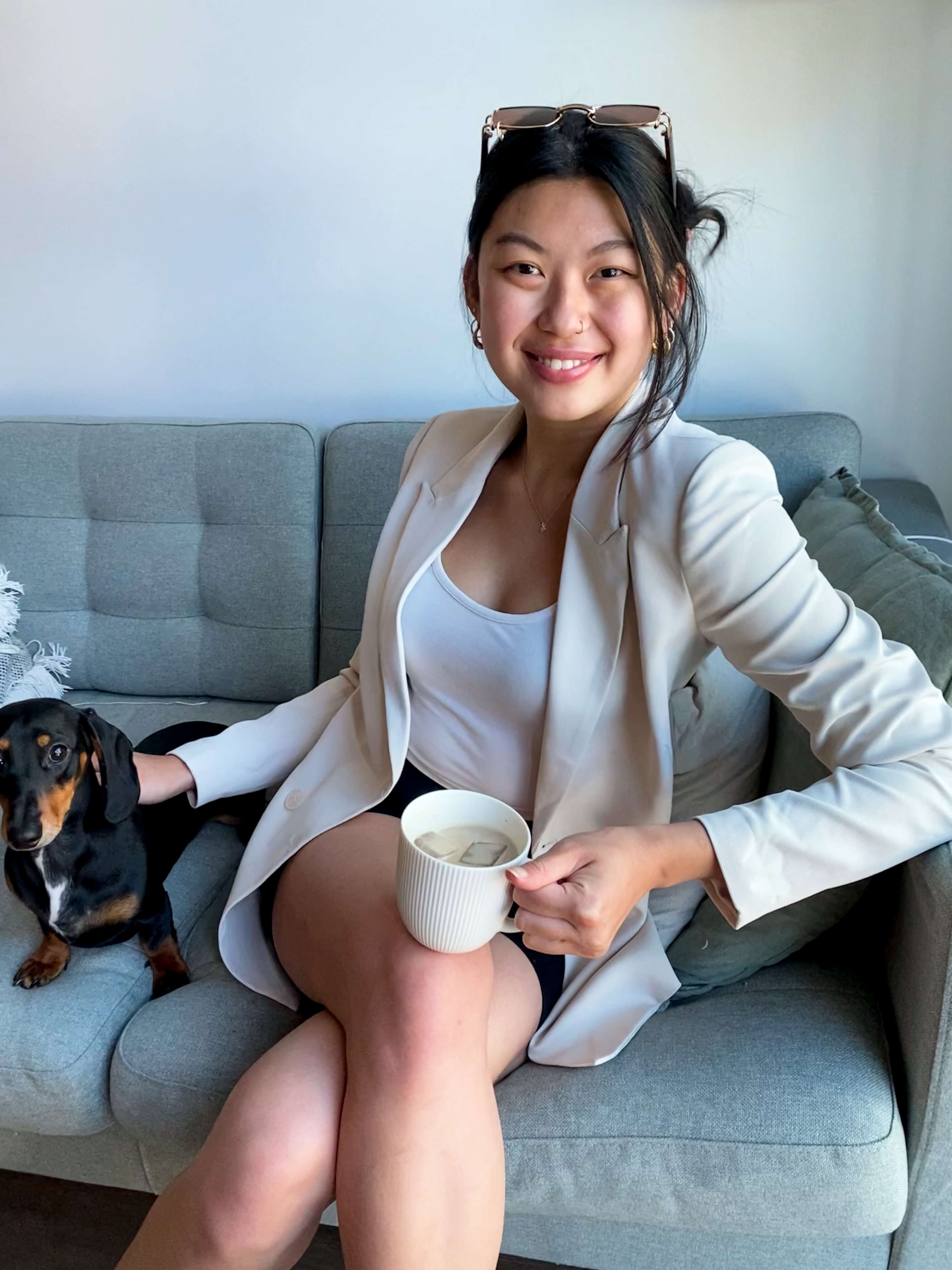 Adelle Yen holding a cup of coffee sitting next to a dog